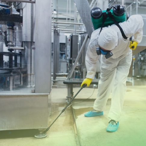 pest control technician in full PPE and suit treating commercial warehouse for pests. Contact BugsBGone for effective commercial pest control in Fort Mill.